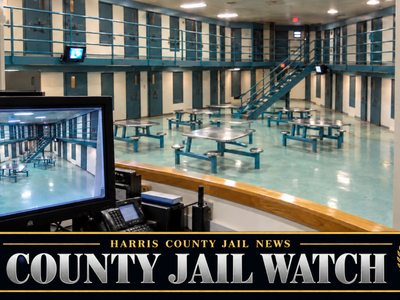 Jail housing unit with steel tables and two tiers of cells, seen from a guard station with a security camera and video monitor, under a Harris County Jail News County Jail Watch banner
